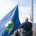 Two Capitol Police officers take down the Vermont state flag outside the Statehouse last week. VTD/Josh Larkin.