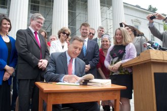 Peter Shumlin signed the historic health care reform act on the Statehouse steps on Thursday. VTD/Taylor Dobbs.