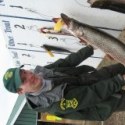 An employee with the Vermont Fish & Wildlife Department holds up a northern pike during a fishing derby on Lake Bomoseen.