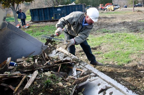 Lt. Gov. Phil Scott shovels debris into a bucket loader at a work site in Berlin's Weston Mobil Home Park, Oct. 31, 2011. VTD/Josh Larkin
