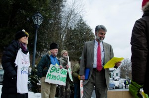 Secretary of the Administration Jeb Spaulding reads over materials handed to him by protestors outside the Statehouse on Thursday. VTD/Josh Larkin