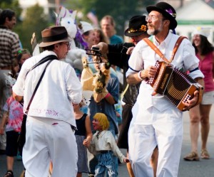 The Midnight Capers Morris dance troop leads a procession of children along Main Street during the New World Festival in Randolph last September. (Photo by Bob Eddy, courtesy of the Herald of Randolph)