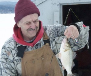 Ron Chaffee poses in front of his shanty with the only white perch he caught on a day when he hauled in more than 40 yellow perch. Photo by Dirk Van Susteren