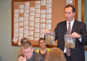 An officer shows House Judiciary Ziploc bags containing 1 ounce and 2 ounces of marijuana. Photo by Alicia Freese
