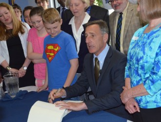 Schoolchildren, educators and legislators look on as Gov. Peter Shumlin signs the FY 2014 budget bill at Milton Elementary School on Tuesday, May 28, 2013. Photo by Alicia Freese