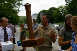 A member of Rising Tide Vermont carries a paper mache rubber stamp in a protest of Vermont Gas Systems' proposed pipeline to Addison County. Photo by Andrew Stein/VTDigger