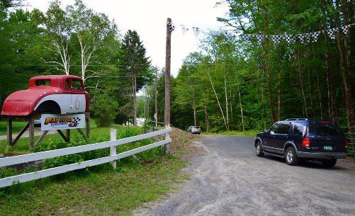 An old coupe marks an entrance in the surrounding forest that leads to Vermont's only dirt race track, Bear Ridge Speedway above the town of Bradford.  Photo by Andrew Nemethy/VTDigger