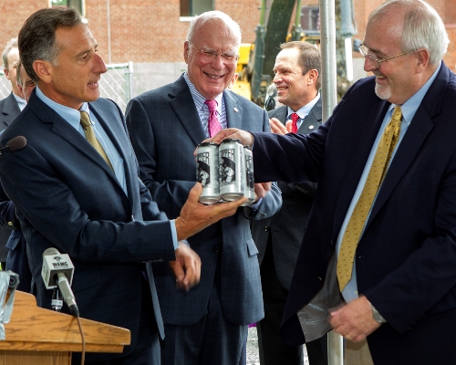 Gov. Peter Shumlin presents FEMA Administrator Craig Fugate with four pack of local Heady Topper beer as U.S. Sen. Patrick Leahy looks on. Photo by Roger Crowley for VTDigger