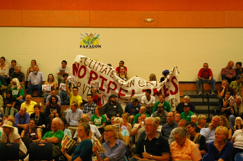 Opponents of the pipeline project raise a banner Wednesday, Photo by Andrew Stein/VTDigger