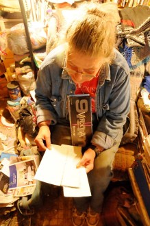 Beverly Grout reviews the journal she keeps on the backs of torn ammunition boxes and finds her notes of when she and her husband were paid for each load of timber. Photo by Hilary Niles/VTDigger 
