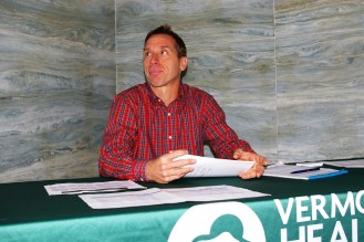 Navigator Peter Sterling, director of the Vermont Campaign for Health Care Security, at his table in the Motor Vehicle Department lobby in Montpelier. Photo by Andrew Stein/VTDigger