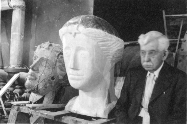 Eighty-seven-year-old Sergeant-at-Arms Dwight Dwinell volunteered to carve the head of a new "Agriculture" in 1938 as part of his job. Thrifty Gov. George Aiken thought the price was about right. Here Dwinell sits beside the head he carved and the head it replaced.  Vermont Historical Society photo
