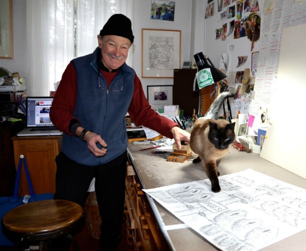 Ed Koren's vocal Siamese feline, "Catmandu," prowls on one of the illustration tables Koren uses to draw in his Brookfield studio. Photo by Andrew Nemethy