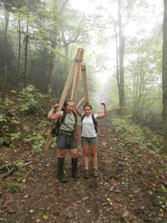 NorthWoods crew leader Cody Sayers, left and volunteer Alex Leston haul timbers a mile to the top of Bald Mountain in Westmore last fall. Photo courtesy of NorthWoods Stewardship Center.