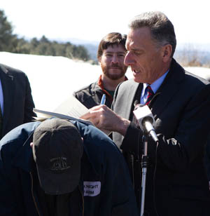 Gov. Peter Shumlin signs a bill on net metering Tuesday, using the back of McKnight Farm owner Seth Gardner as a desk. Photo by Roger Crowley/for VTDigger