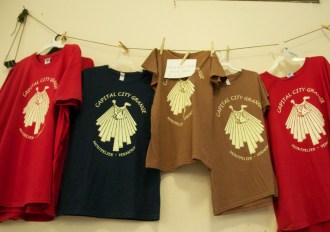 Grange T-shirts for sale hang from a string at the Capital City Grange. Photo by Dirk Van Susteren