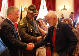 Peter Mason, 86, is congratulated by Col. Thomas L'Esperance for his help in the 1944 rescue of survivors of a B-24 plane crash on Camels Hump. Photo by Laura Krantz/VTDigger