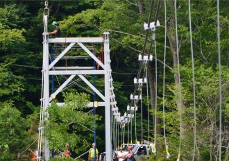 Work crews string the cables that will support a new footbridge across the Winooski River in Bolton. The $2.3-million project of the Green Mountain Club will provide a permanent, protected footpath between Camels Hump and Bolton Mountain on a rerouted Long Trail. Mike DeBonis, new executive director of the Green Mountain Club, says trail relocation and the footbridge will end a 100-year search for a way across the Winooski Valley that does not require either a boat or a long road walk. Photo by Jocelyn Hebert, courtesy of the Green Mountain Club. 