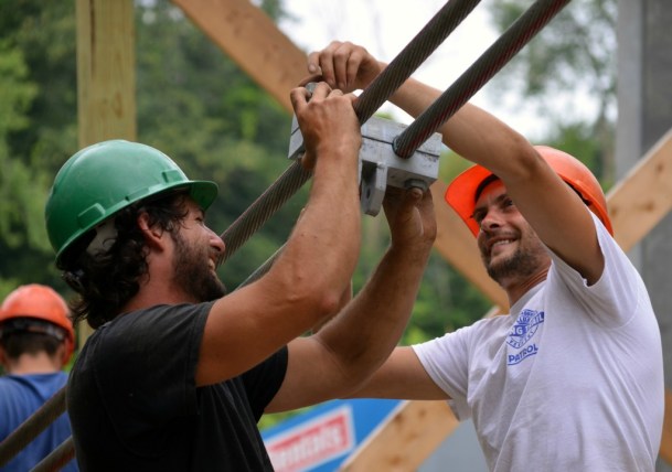Pat O'Brien, left, and project manager Matt Wels work on suspension cables high above the Winooski River in Bolton. The Green Mountain Club's new hiker footbridge will cross at a height that protects it from high water like that seen during Tropical Storm Irene in 2011. Photo by Jocelyn Hebert, courtesy of the Green Mountain Club. 