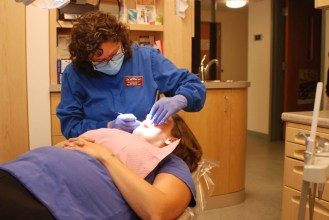 Dental hygienist Michele Feccia works on a patient at The Health Center in Plainfield. Photo by Morgan True/VTDigger 