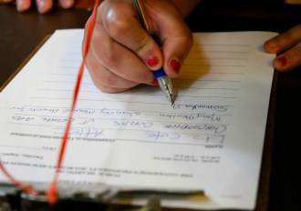 Samantha Shoram signs up as a witness at Tuesday's public hearing on proposed budget cuts. Photo by Hilary Niles/VTDigger
