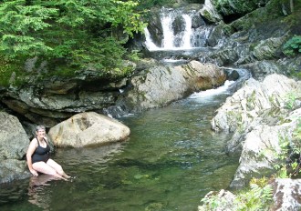 Liz Slayton of Montpelier, wife of the writer of this column, cools off on a hot day at the bank of Journey's End swimming hole in Johnson, which features 100 yards of waterfalls, pools and clear, cold water. Photo by Tom Slayton 