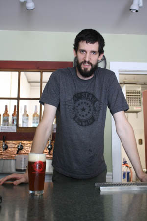 14th Star Brewery brewmaster Dan Sartwell show off his new creation The Raider. St. Albans Messenger photo 