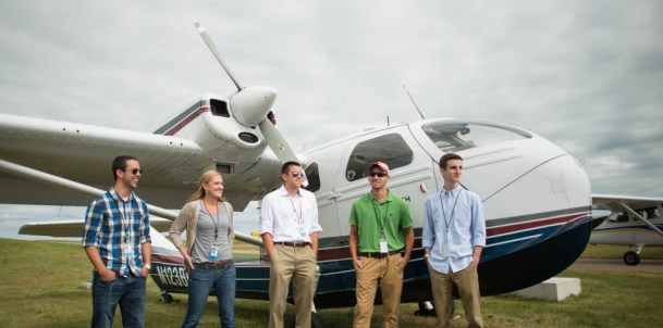 Students stand near VTC newest training plane at Burlington International Airport.