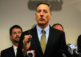 Gov. Peter Shumlin holds up a cell phone to emphasize the viability of the semi-conductor manufacturing business that takes place in Essex Junction. IBM announced Monday it would sell the division to California-based, Abu Dhabi-owned GlobalFoundries. Photo by Hilary Niles/VTDigger 