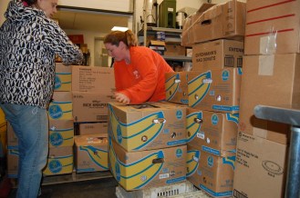 Employees stack boxes at the Community Kitchen Academy in Barre. Photo by Laura Krantz/VTDigger