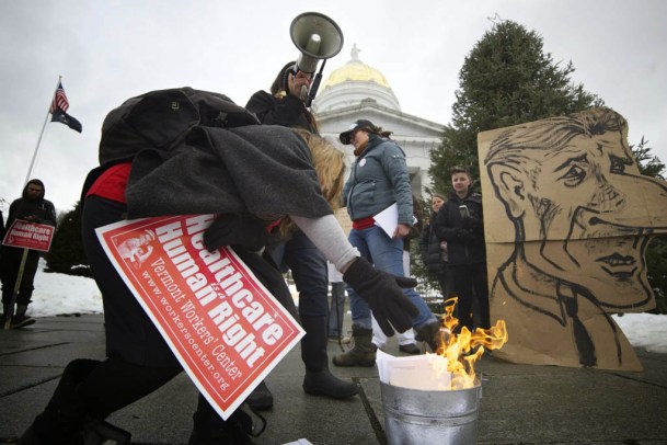 A protester burns a medical bill in a demonstration against Gov. Peter Shumlin's decision not to pursue single payer health care in the next legislative session. Photo by John Herrick/VTDigger