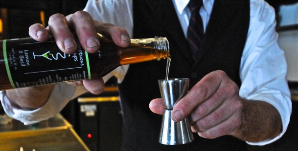 Don Horrigan measures his Lemon-Basil syrup, which is produced by a company, Sumptuous Syrups of Vermont, that he co-owns and that is based in Hardwick. Photo by Dirk Van Susteren 