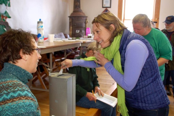 Elmore voter Jessica Dambach casts her ballot at the annual Town Meeting in Elmore on a question about entering a merger study with the Morristown School District. Voters had to give their names for the checklist to ensure only one vote per voter was used.