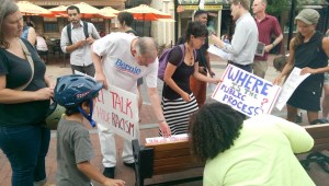 People pick up signs outside Burlington City Hall on Monday before a City Council meeting to confirm NYPD Inspector Brandon del Pozo as the city's next police chief. Photo by Sarah Olsen/VTDigger