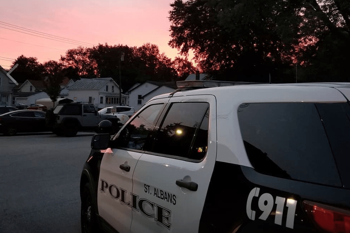 A police car parked on a street at sunset.