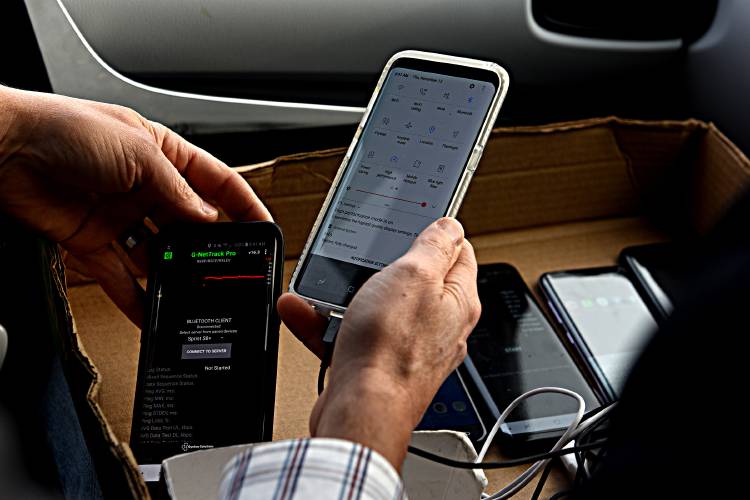 Corey Chase checks the app on the phones he is running