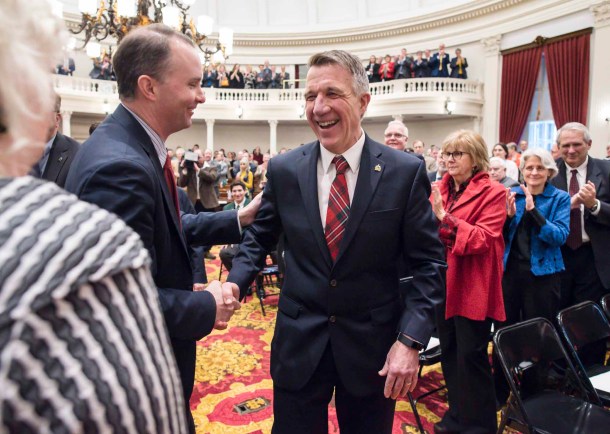 Gov. Phil Scott shakes hands with Attorney General TJ Donovan as he arrives to deliver his budget address