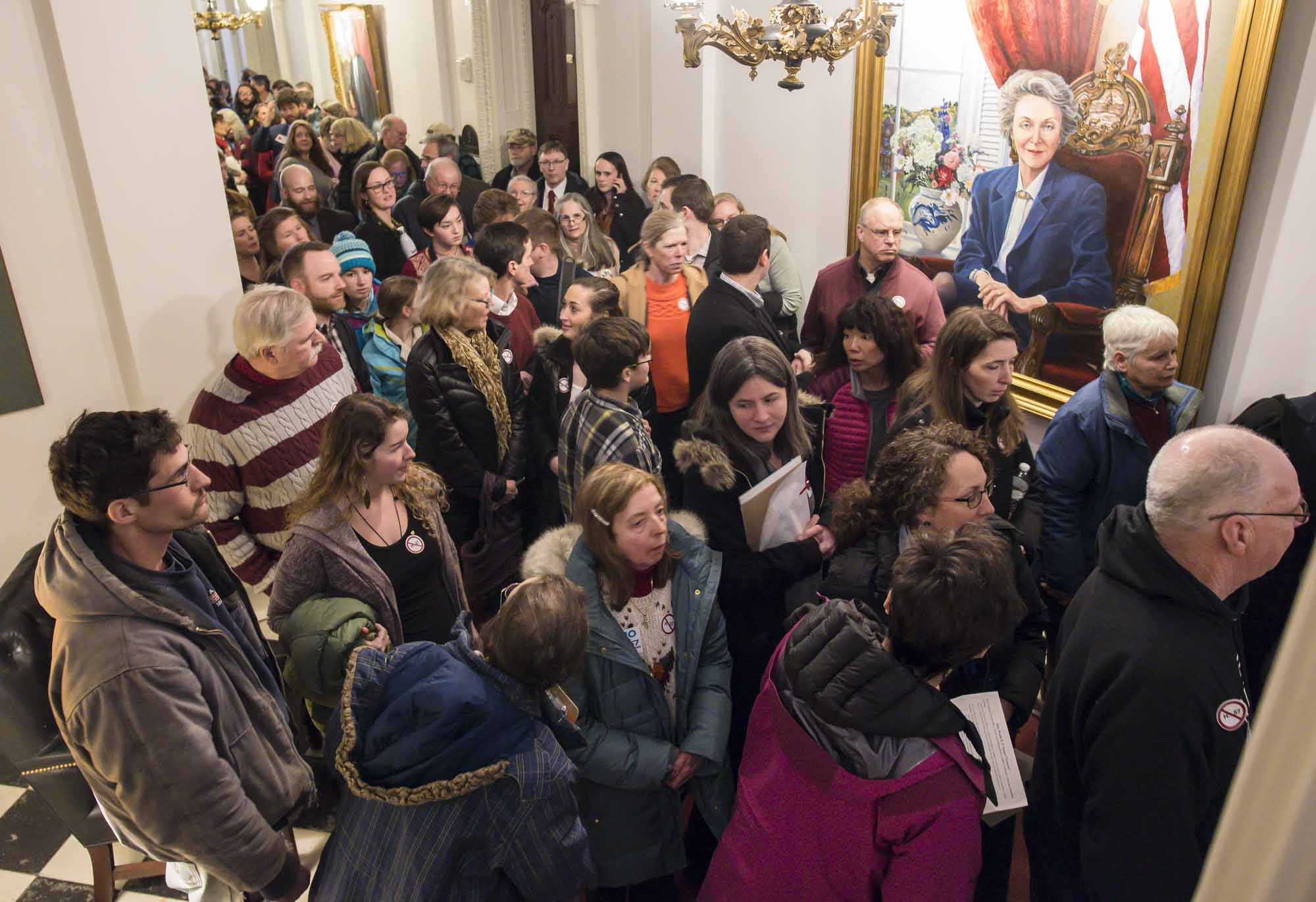 People crowd the halls of the Statehouse before a public hearing on an abortion rights bill.