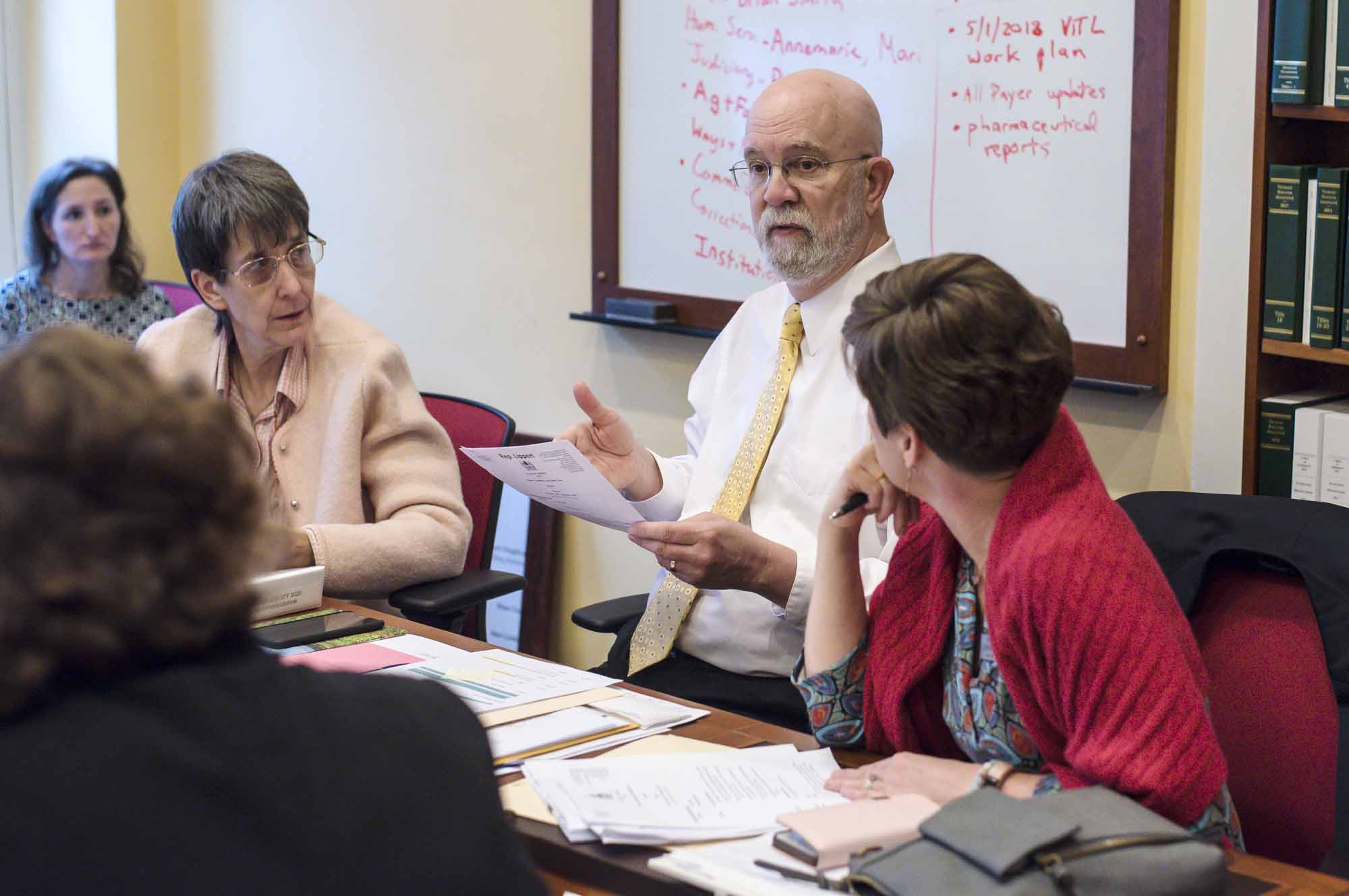 Bill Lippert confers with committee vice-chair Rep. Anne Donahue, R-Northfield, left, and ranking member Rep. Lori Houghton, D-Essex Junction, at the Statehouse.