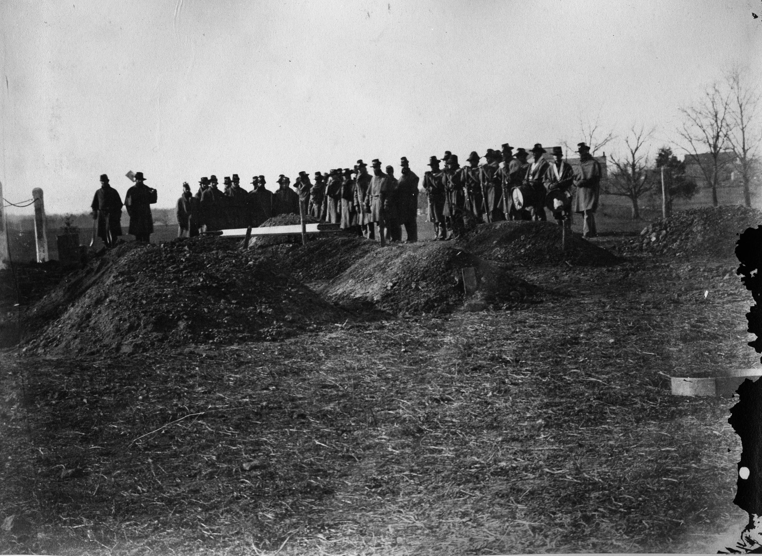 Union soldiers stand at a burial site