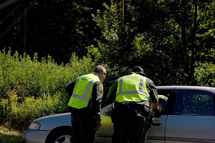 Two agents speak with a driver