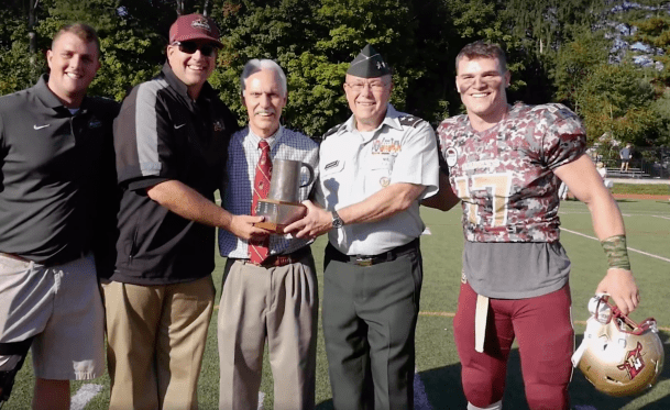 Owen McKenna, far right, alongside longtime Norwich President Richard Schneider, to his left, after Saturday's victory over the Coast Guard.