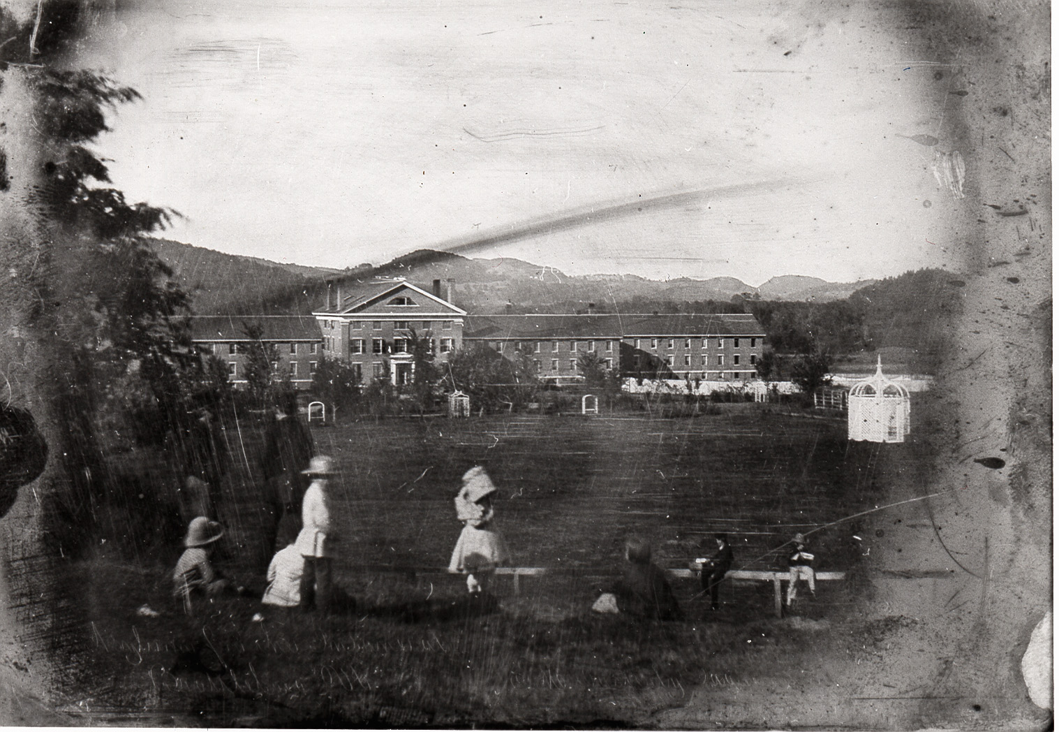 A daguerreotype of people and buildings in the background