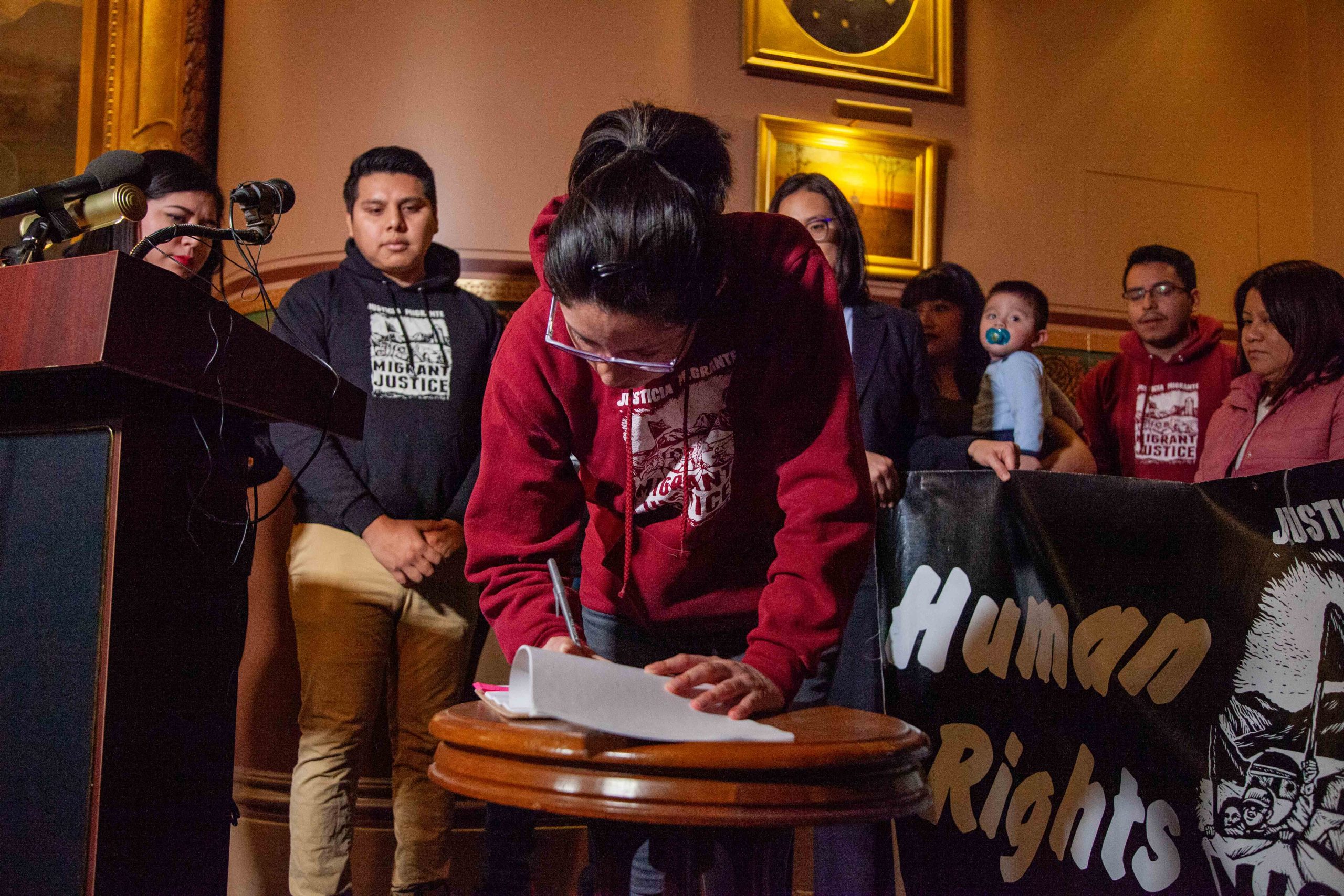 Migrant Justice reps sign settlement agreement