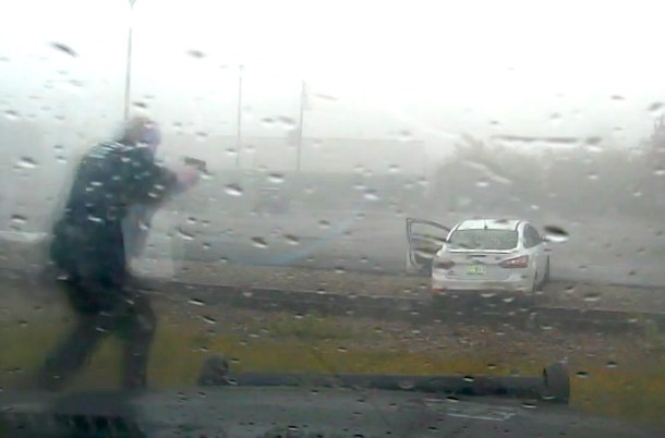 Police officer approaches white car