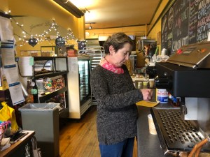 Line Barral, who co-owns Cafe Provence restaurant and the Gourmet Provence cafe and store, makes coffee Tuesday afternoon. Barral closed the restaurant but will start offering some takeout meals at the neighboring cafe in response to Gov. Phil Scott's order closing all restaurants and bars to dine-in service. Photo by Anne Wallace Allen/VTDigger