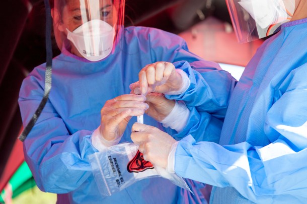 Workers holding medical storage bag