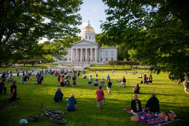 Demonstrators kneeling on Statehouse lawn