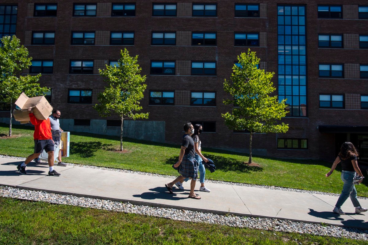 A group of people walking down a sidewalk.