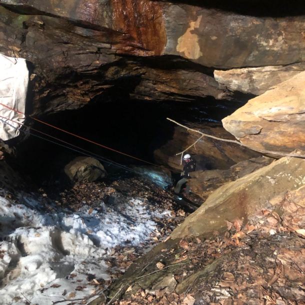 Man with ropes attached to him in copper mine